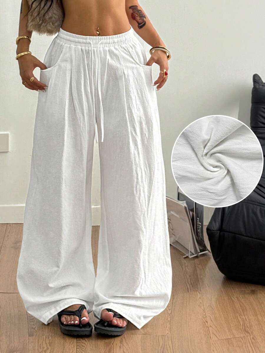 Women's loose fit brown and tan plaid wide leg pants featuring an elastic drawstring waist and side pockets.