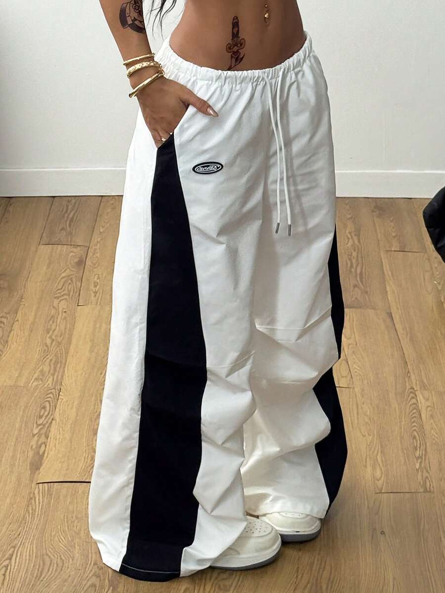 Women's high waist wide leg pants in black featuring leopard print patchwork details and an elastic drawstring waistband.