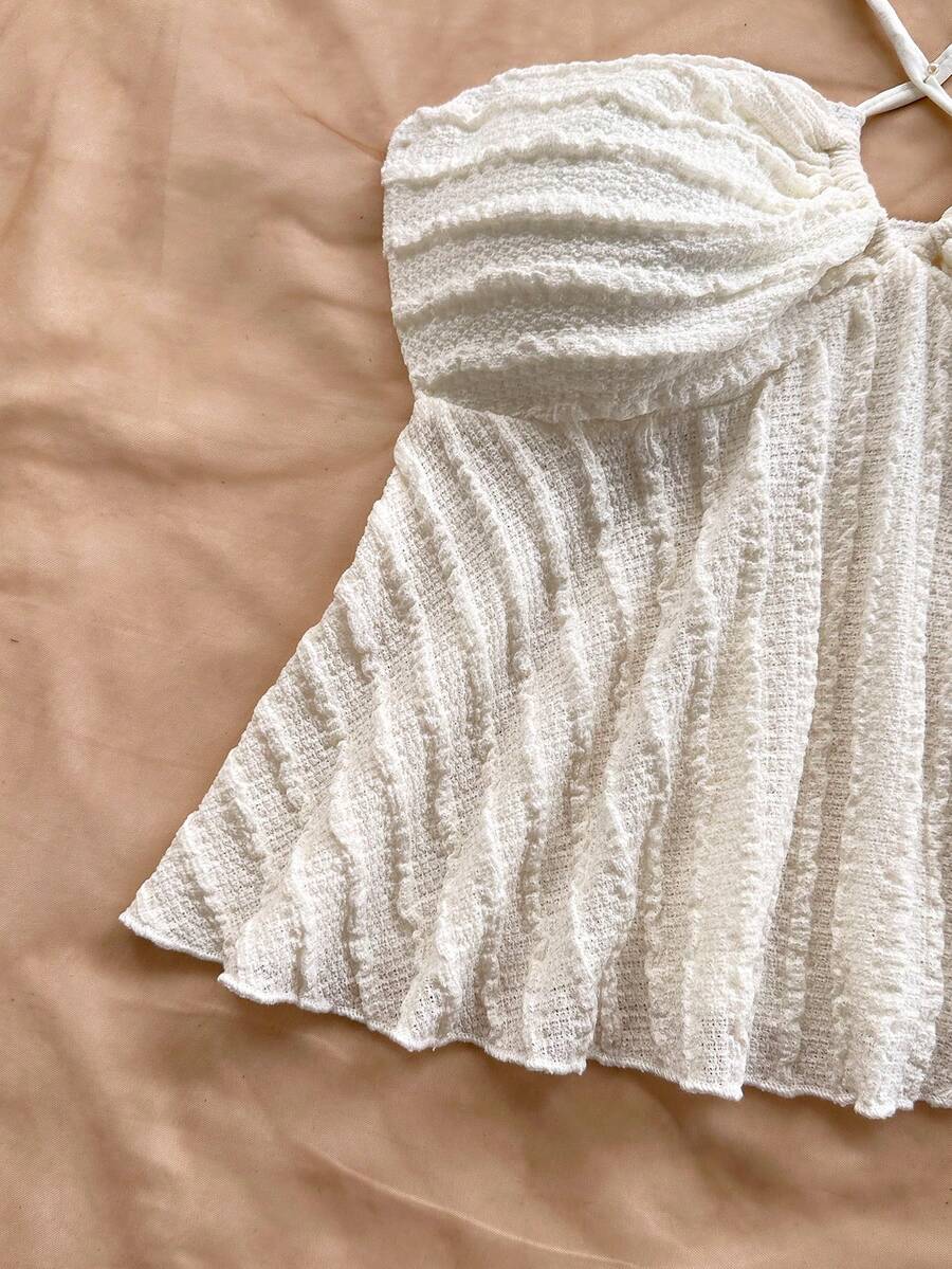 Women's textured V-neck halter tank top with backless knot detail, ruffle hem, and flared silhouette for casual beach and vacation wear.