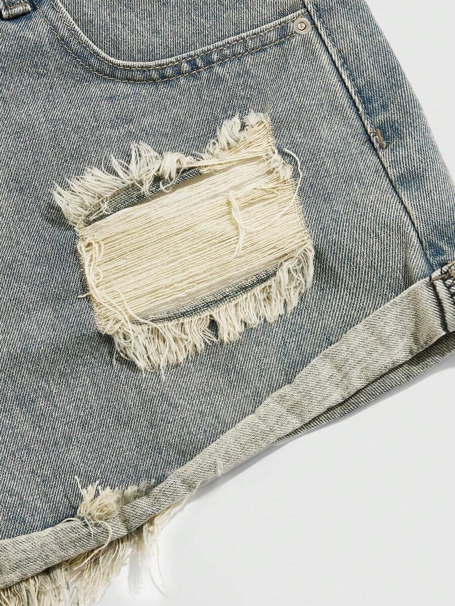 Front view of women's ripped denim shorts featuring raw hem, zipper fly, and pockets