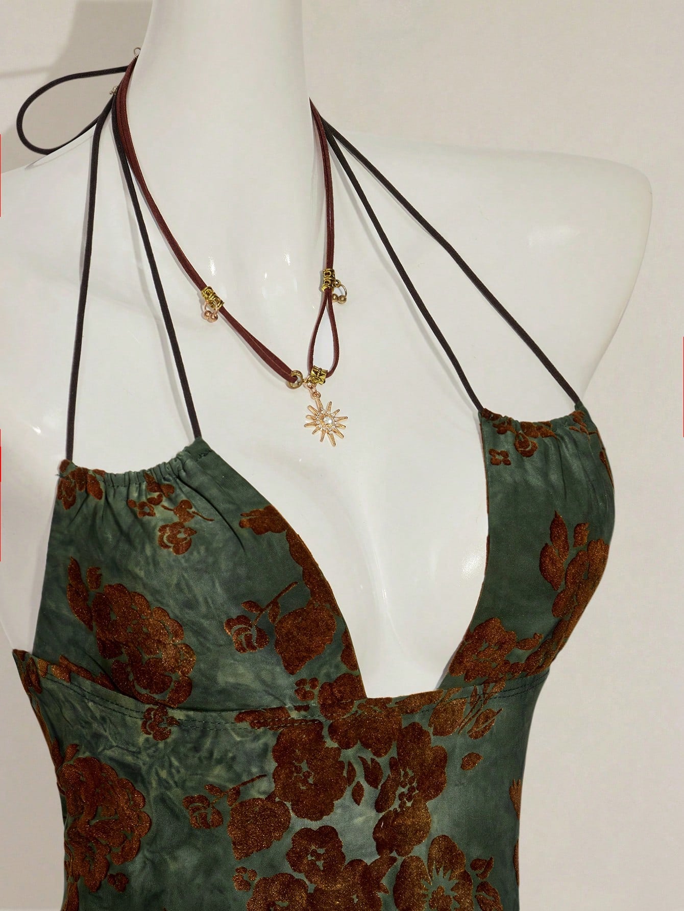Women's green flocked jacquard halter tank top with plant pattern, criss-cross straps, deep V-back, knot detail, backless cut, and asymmetrical micro crop hem.