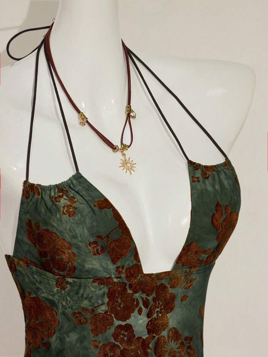 Women's green flocked jacquard halter tank top with plant pattern, criss-cross straps, deep V-back, knot detail, backless cut, and asymmetrical micro crop hem.