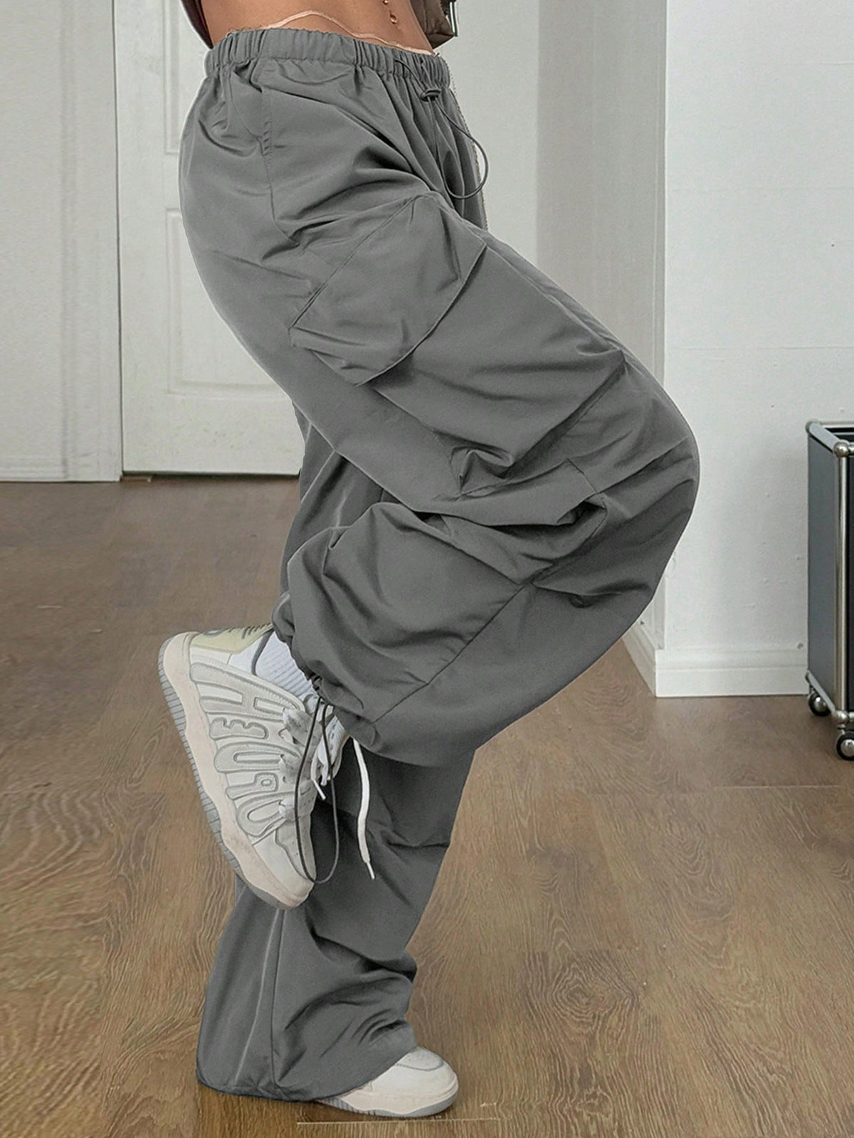 Women's loose fit parachute cargo pants featuring a drawstring waist and functional pockets in a casual streetwear style