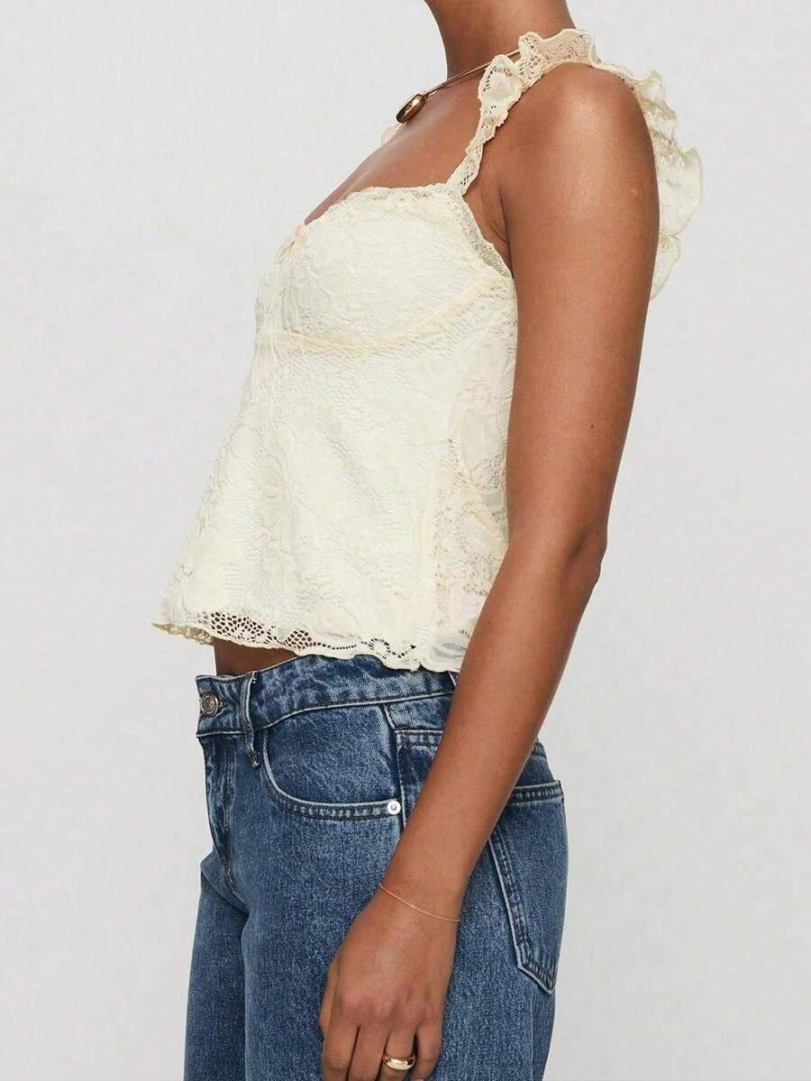 Sleeveless cami tank top featuring contrast lace patchwork design, ruffle spaghetti straps, and bow decor.