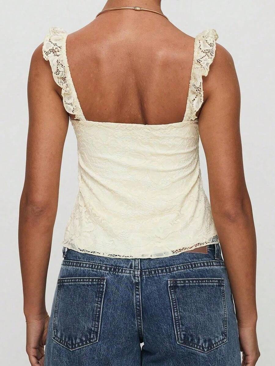 Sleeveless cami tank top featuring contrast lace patchwork design, ruffle spaghetti straps, and bow decor.