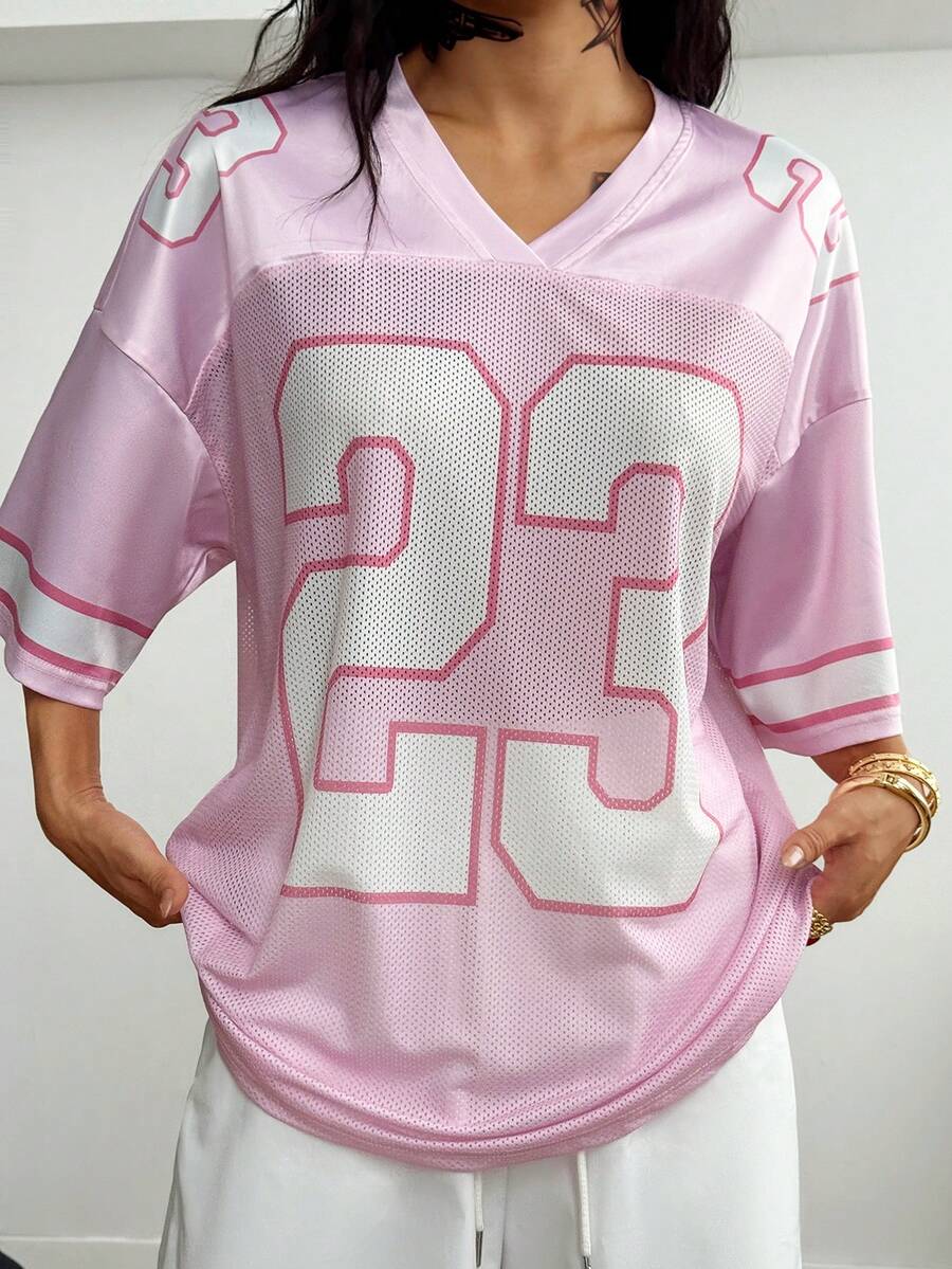 Oversized short-sleeve football jersey top featuring a V-neckline, contrast binding, and graphic number print.