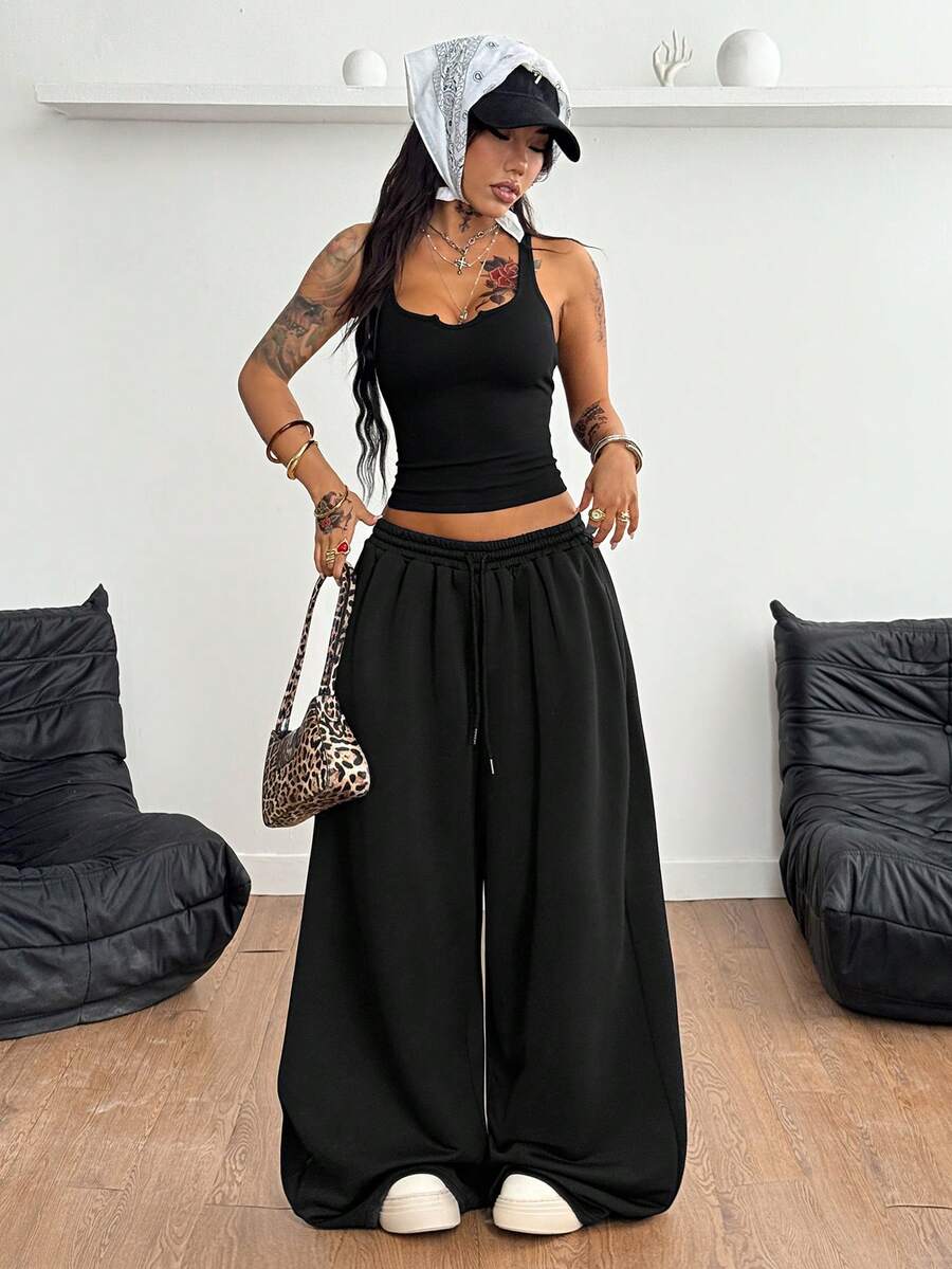 Women's two-piece casual outfit featuring a slim-fit camisole tank top with ruffle trim and button front paired with high-waisted wide leg pants.