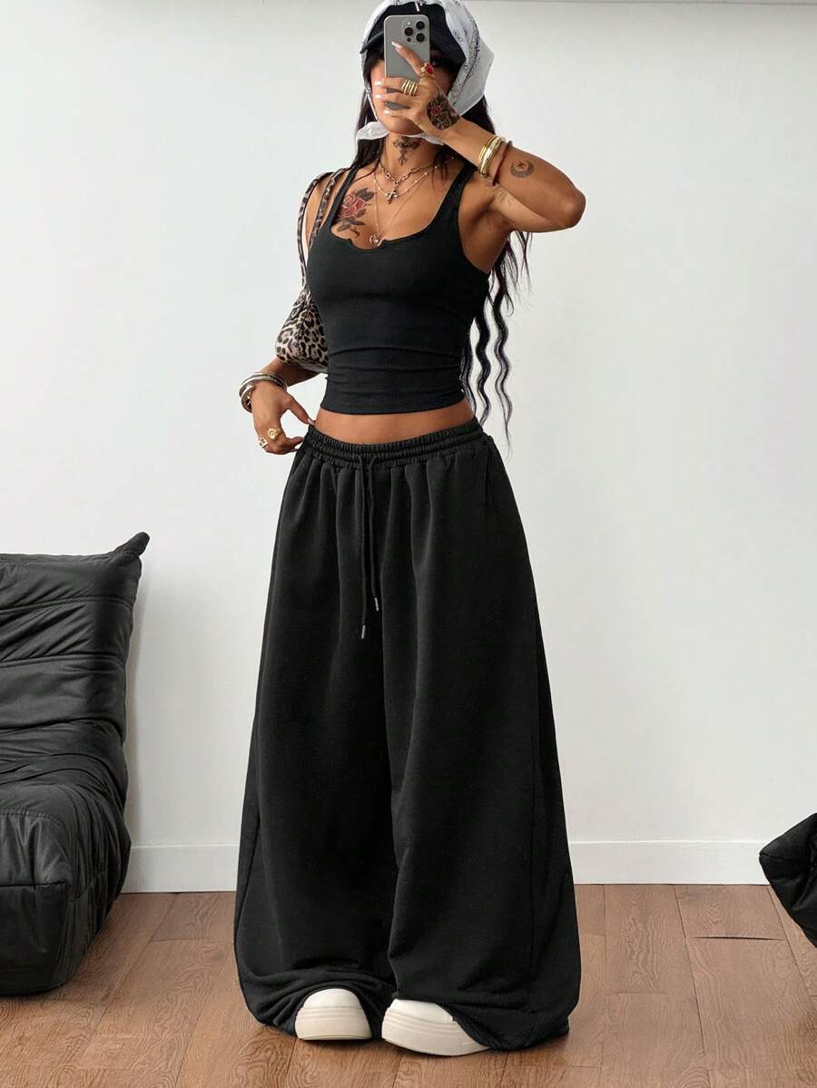 Women's two-piece casual outfit featuring a slim-fit camisole tank top with ruffle trim and button front paired with high-waisted wide leg pants.