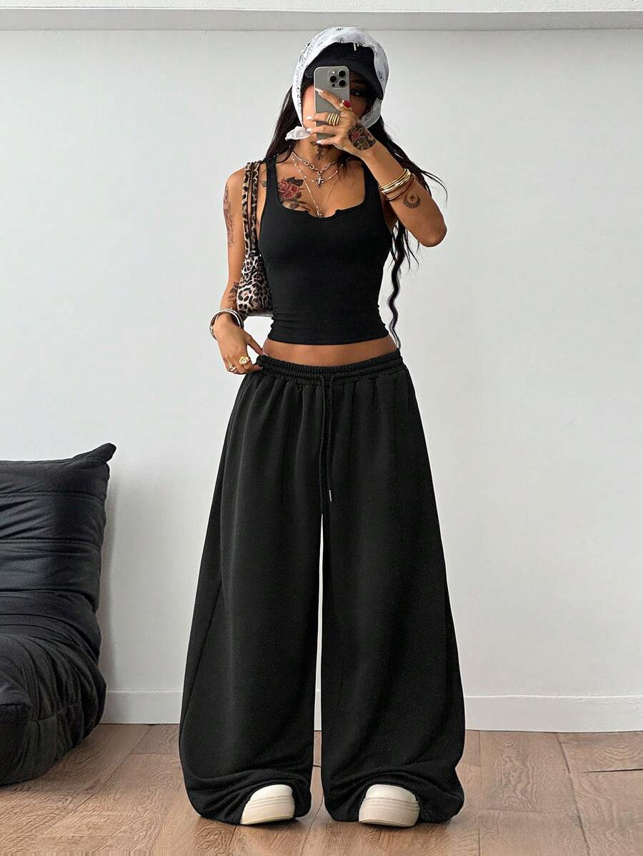 Women's two-piece casual outfit featuring a slim-fit camisole tank top with ruffle trim and button front paired with high-waisted wide leg pants.