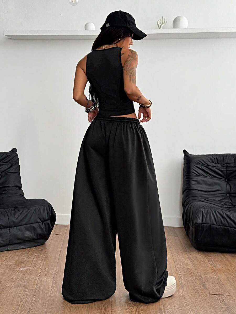 Women's two-piece casual outfit featuring a slim-fit camisole tank top with ruffle trim and button front paired with high-waisted wide leg pants.