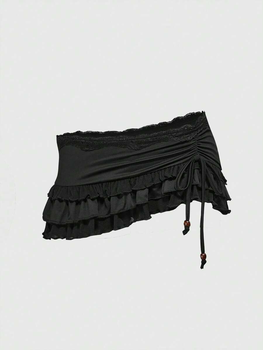 Women's black low-waist mini skirt with drawstring tie, ruched details, lace trim, layered ruffle hem, and asymmetric styling