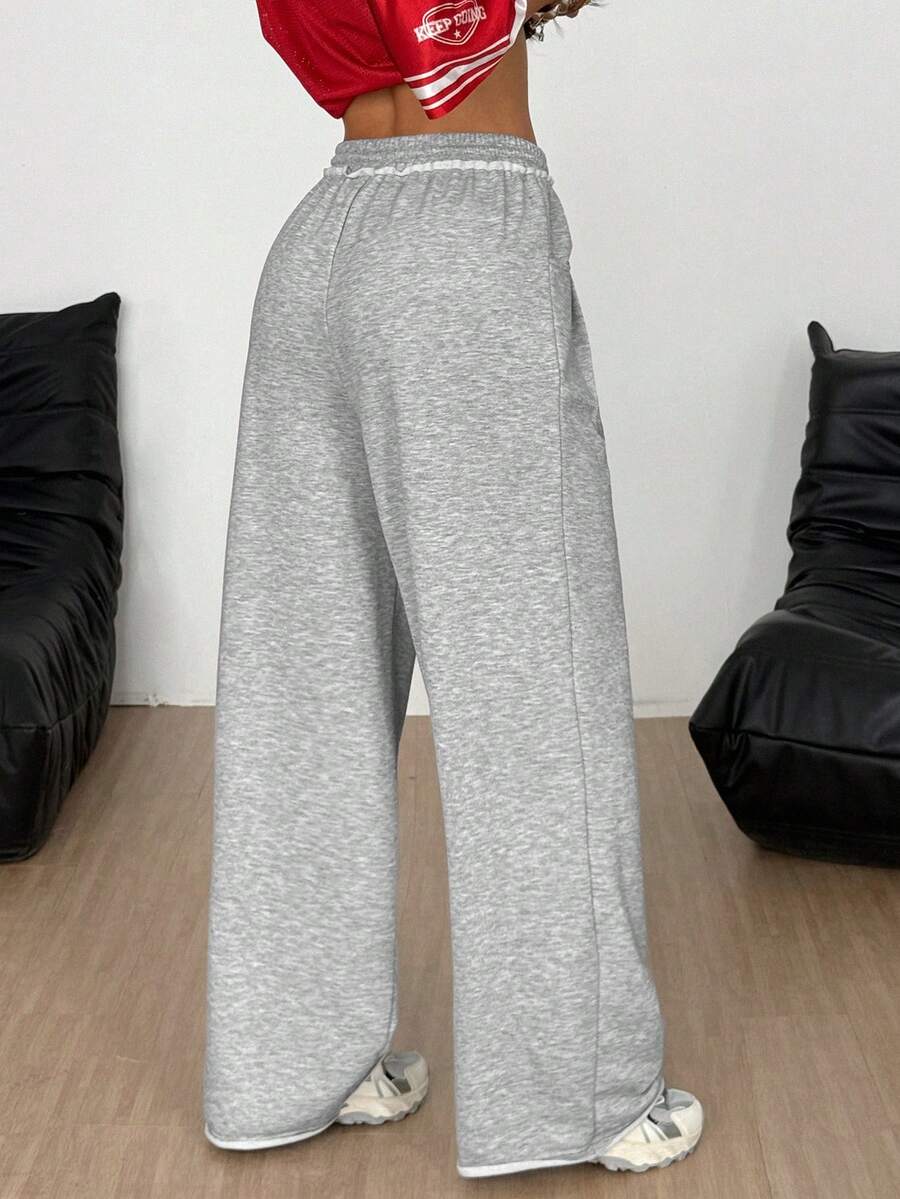 Women's casual straight leg baggy lounge pants in light grey with an adjustable drawstring waist and side pockets.