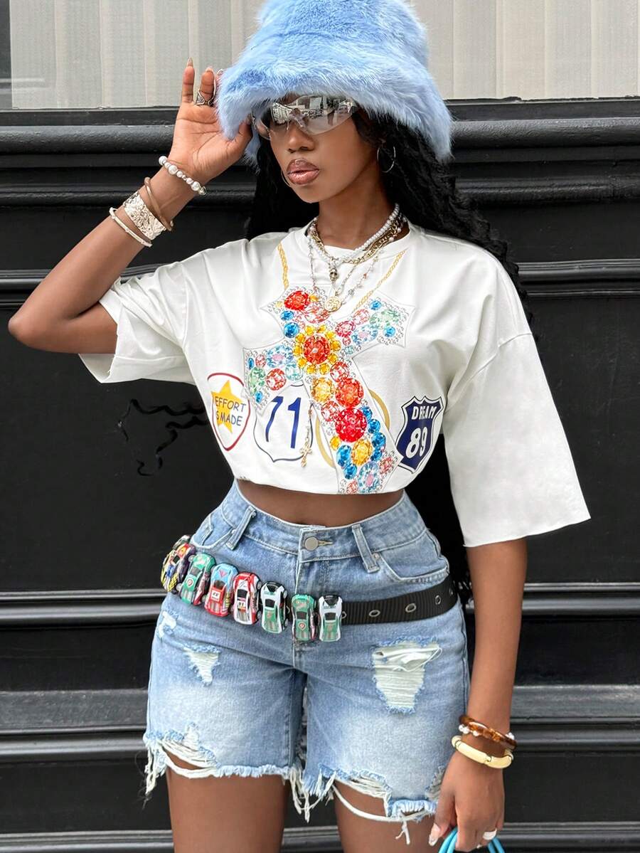 Front view of a women's black oversized crop t-shirt with pink lips graphic, round neckline, and short drop-shoulder sleeves.
