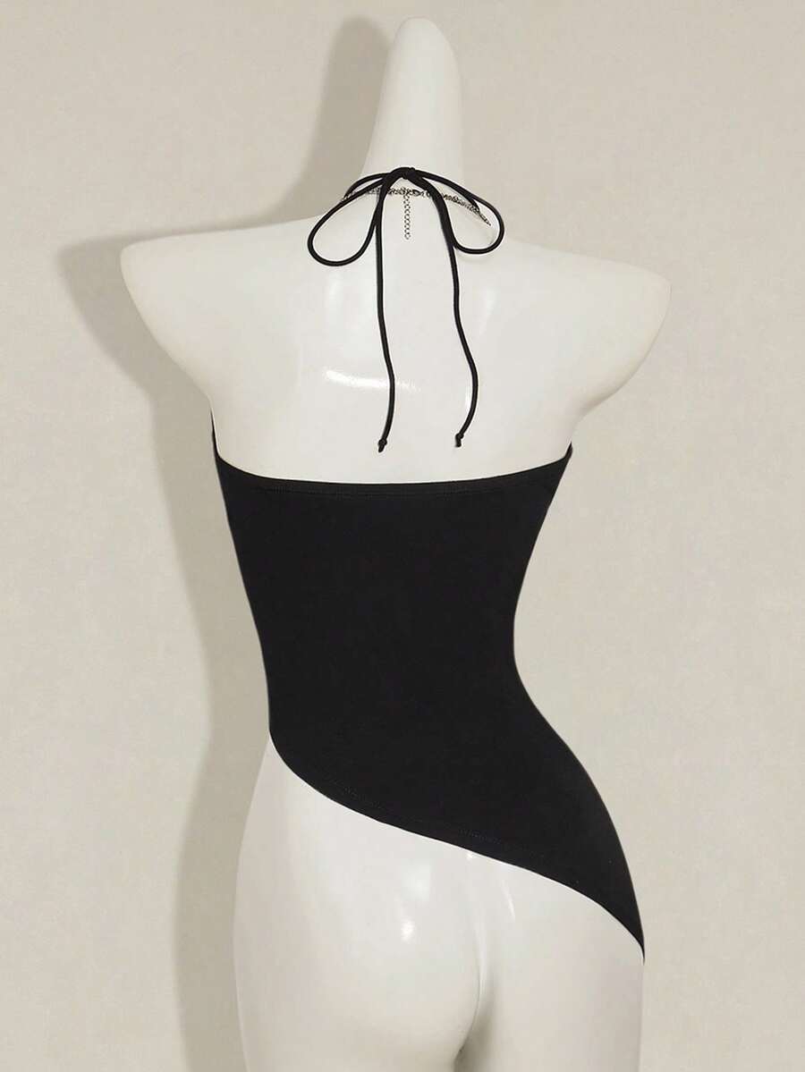 Women's black asymmetrical knitted halter top featuring a slim fit and colorblock pattern