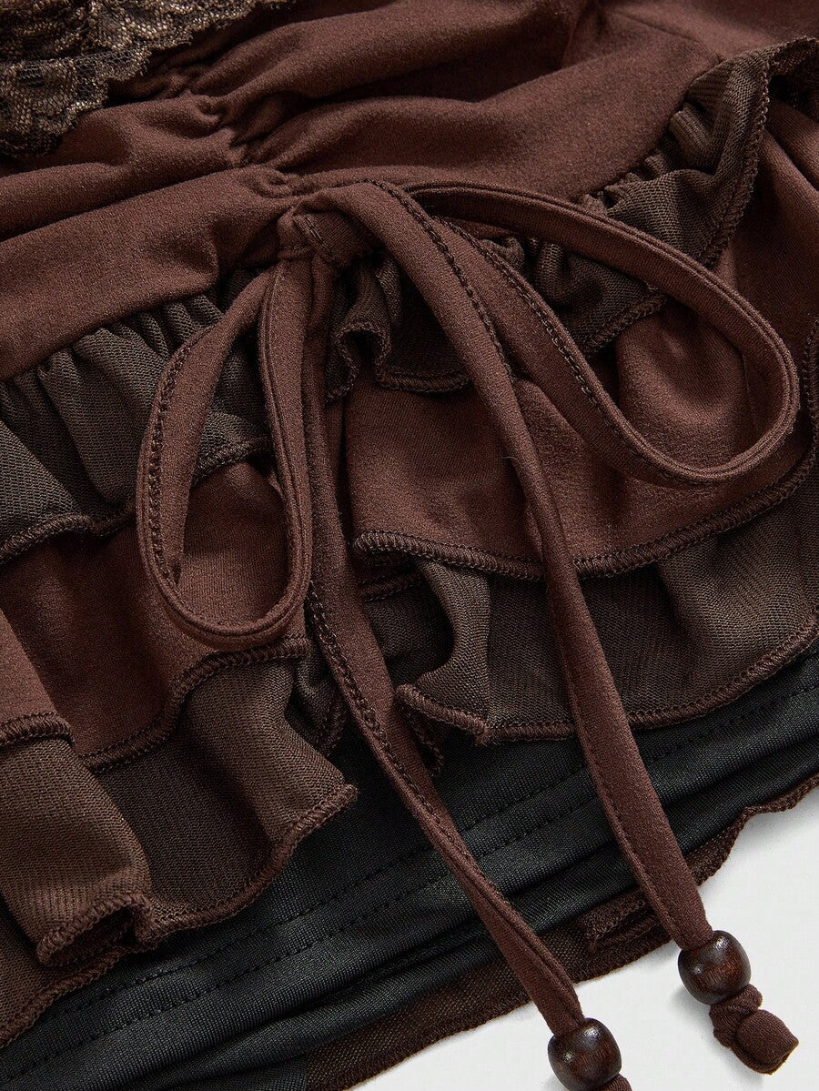 Women's black low-waist mini skirt with drawstring tie, ruched details, lace trim, layered ruffle hem, and asymmetric styling