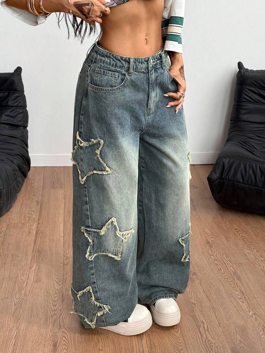 Women's loose fit baggy jeans in washed denim featuring star patches, slant pockets, and a mid-rise cut.