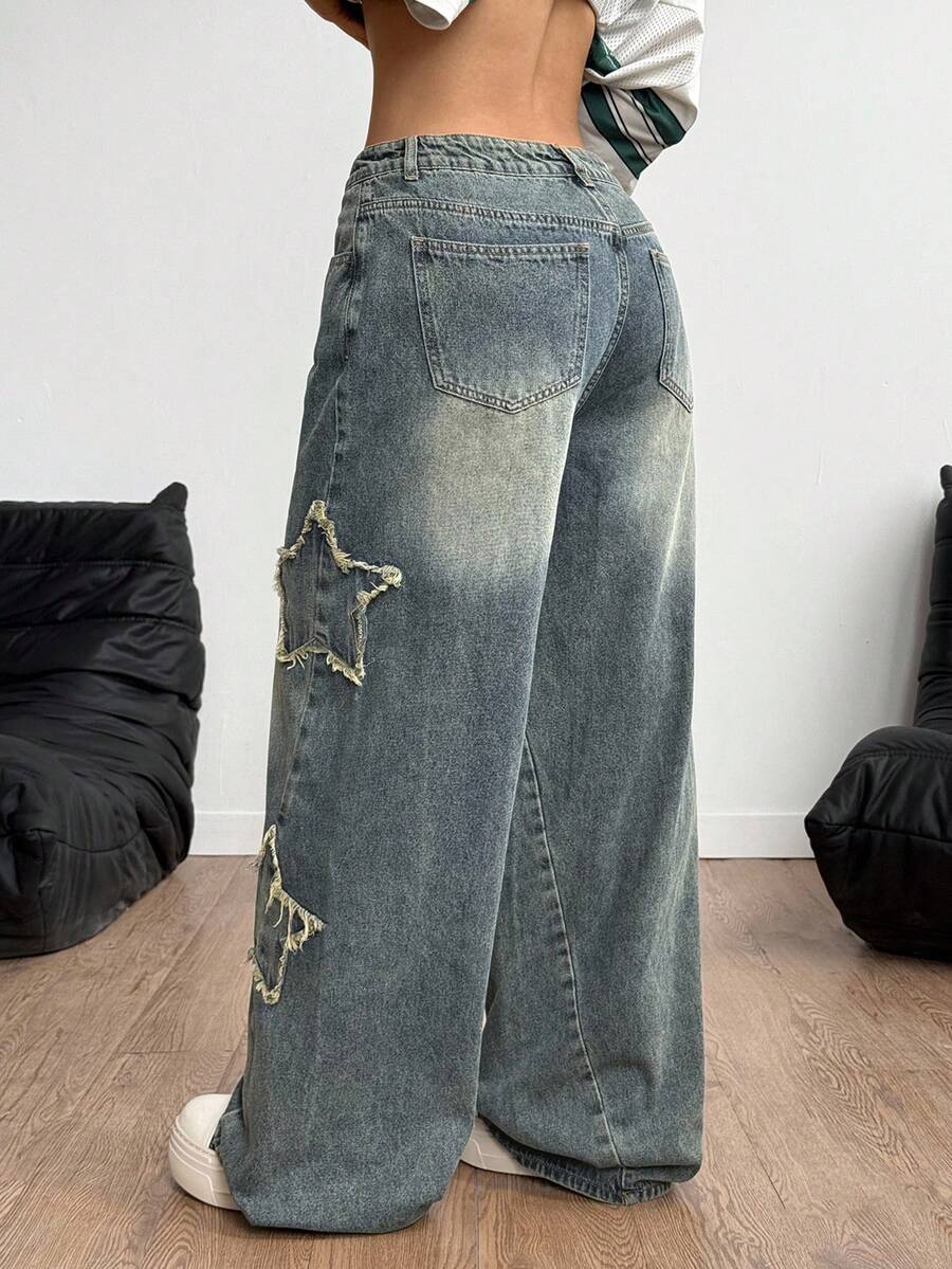 Women's loose fit baggy jeans in washed denim featuring star patches, slant pockets, and a mid-rise cut.