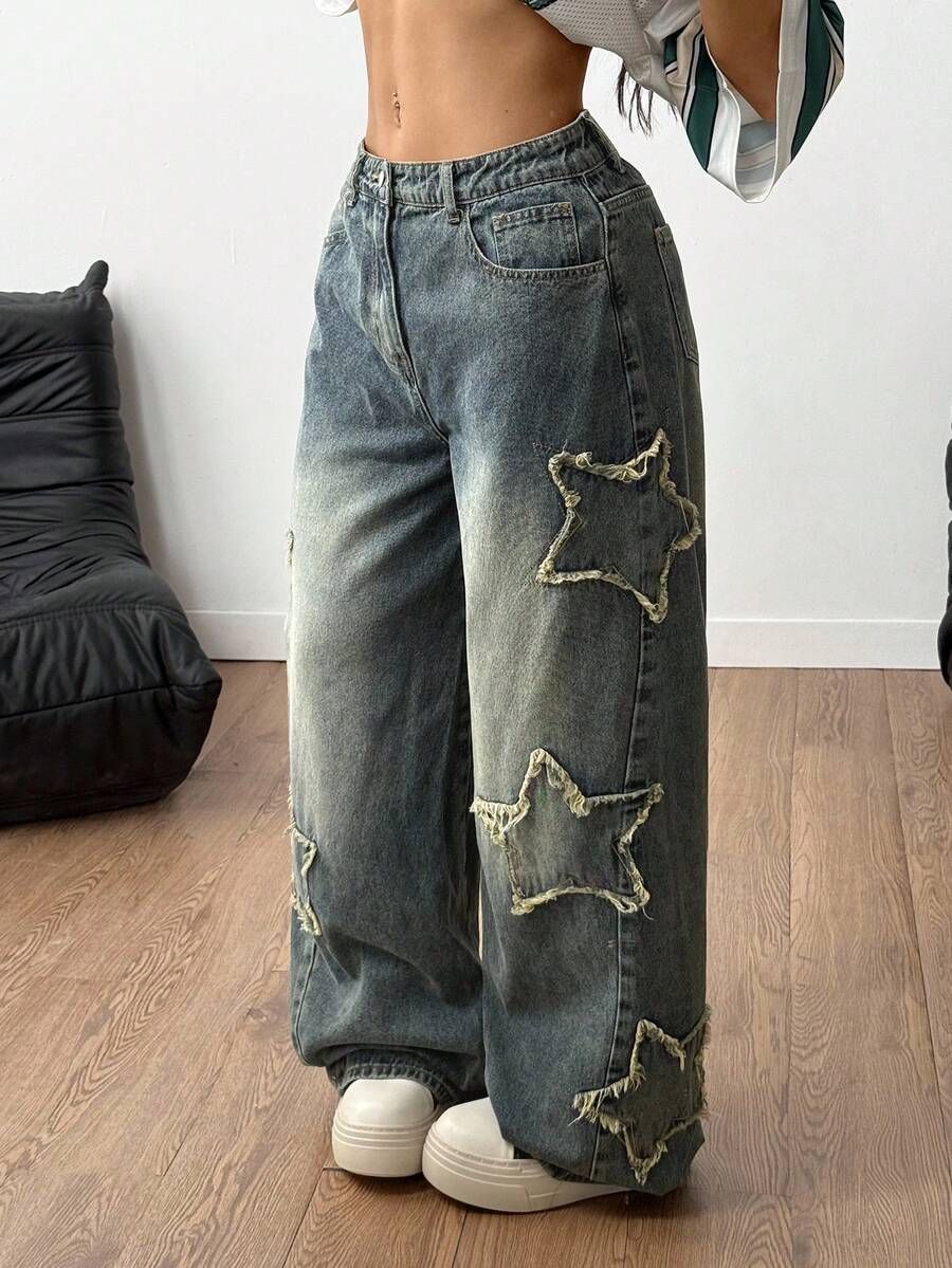 Women's loose fit baggy jeans in washed denim featuring star patches, slant pockets, and a mid-rise cut.