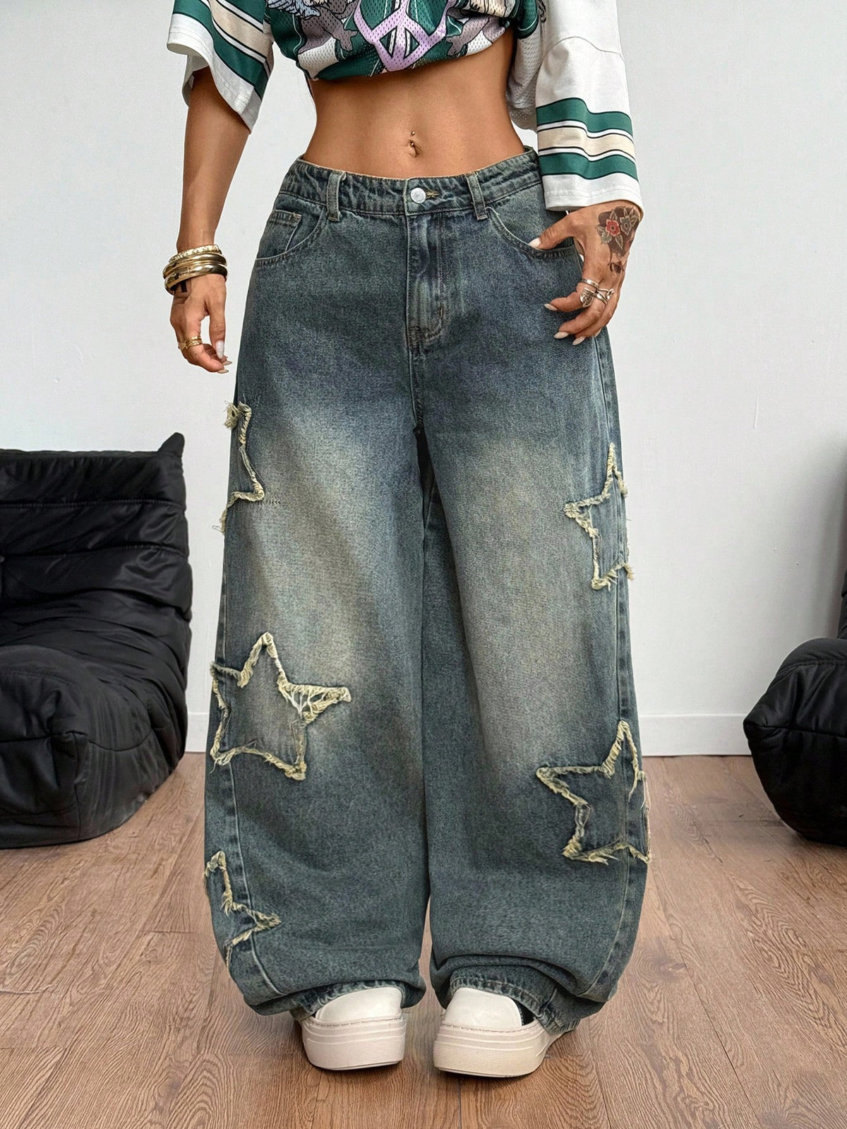 Women's loose fit baggy jeans in washed denim featuring star patches, slant pockets, and a mid-rise cut.