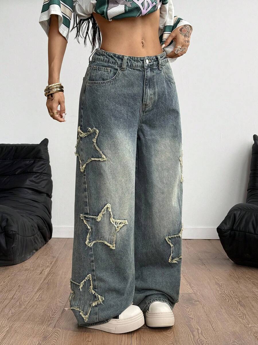 Women's loose fit baggy jeans in washed denim featuring star patches, slant pockets, and a mid-rise cut.