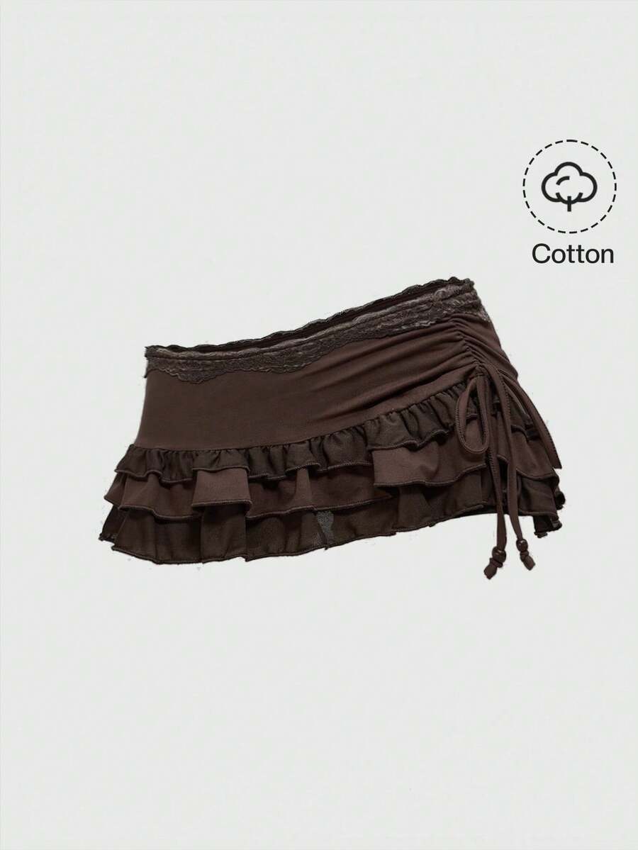 Women's black low-waist mini skirt with drawstring tie, ruched details, lace trim, layered ruffle hem, and asymmetric styling