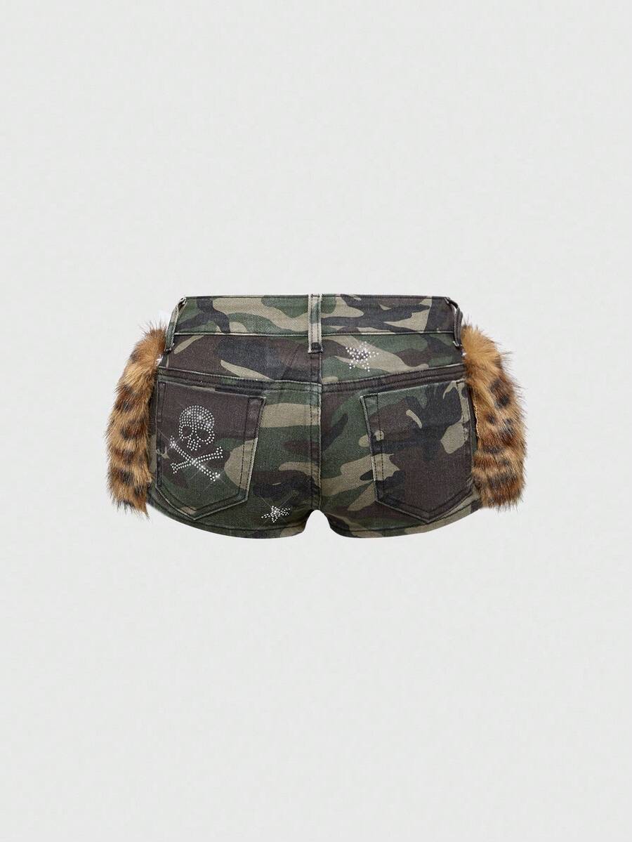Army green Y2K K-pop style ultra low waist mini shorts with patchwork camo, star graphic details, rhinestone decoration, zipper fly, and pockets.