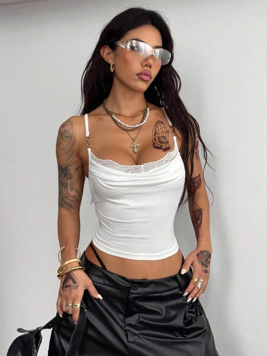 Women's black knit slim fit camisole top featuring contrast lace detailing, a backless design, ruched accent, and thin spaghetti straps.