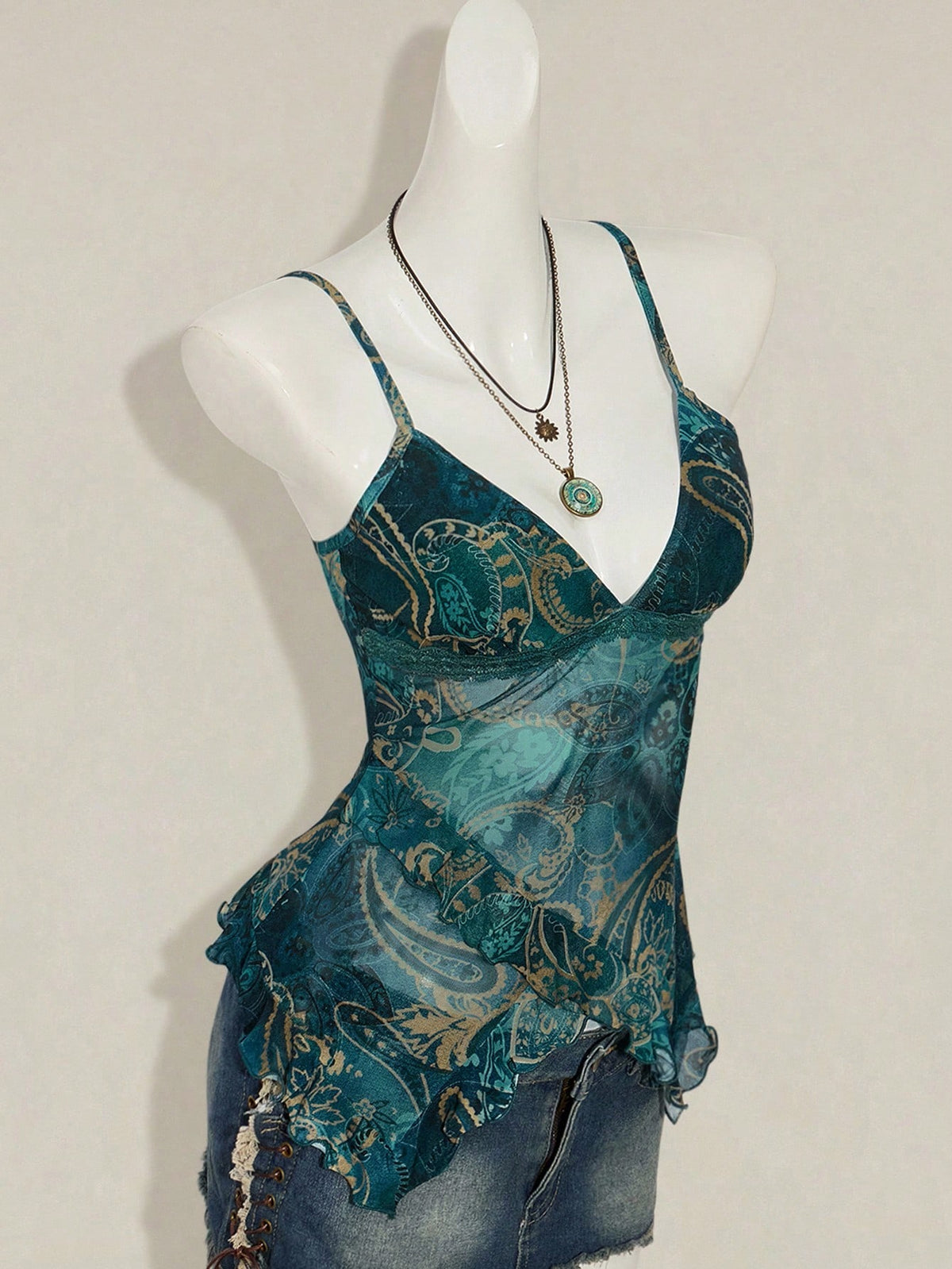 Women's graphic print camisole top featuring thin spaghetti straps, a backless cut, and an asymmetrical hem.