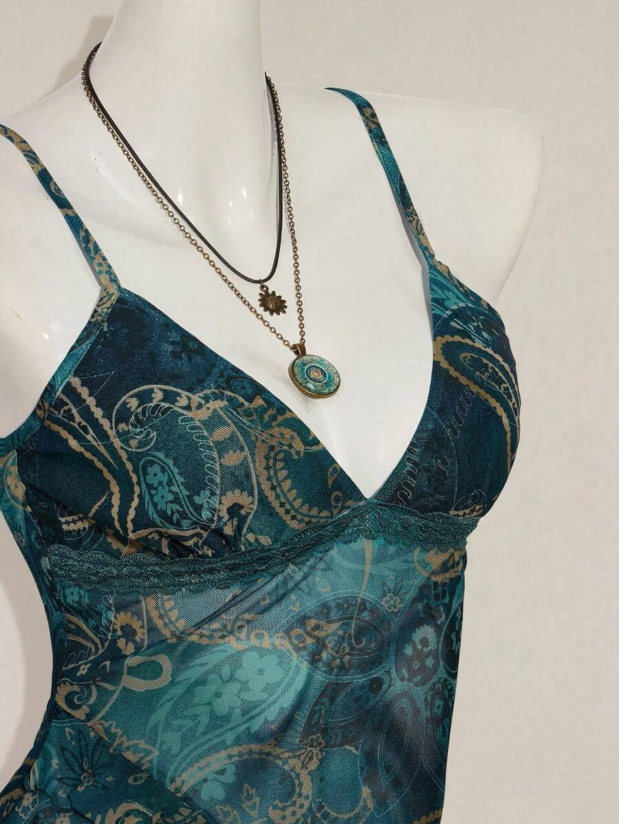 Women's graphic print camisole top featuring thin spaghetti straps, a backless cut, and an asymmetrical hem.