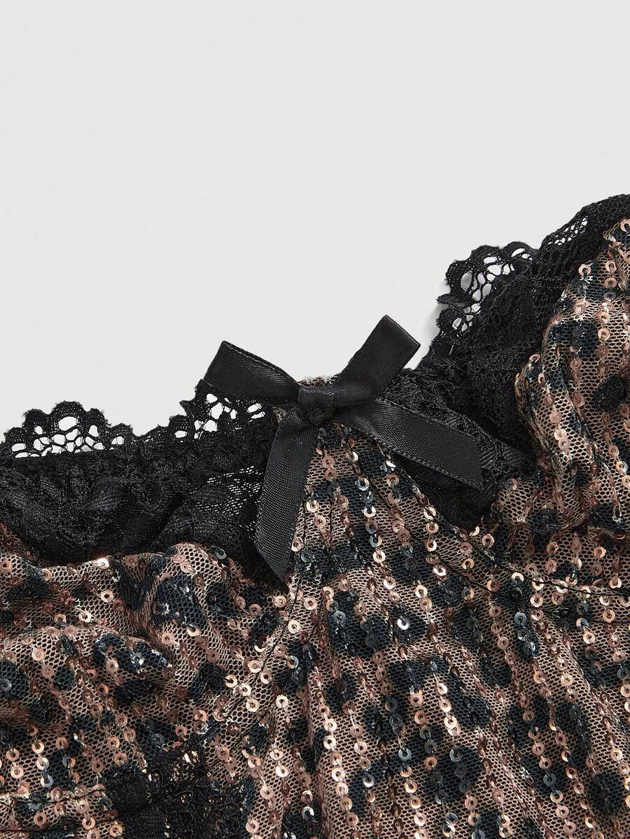 Black Y2K two-piece party set featuring a shiny sequin strapless micro crop bandeau top with cup details and bow, paired with matching lined mini shorts with contrast lace trim.