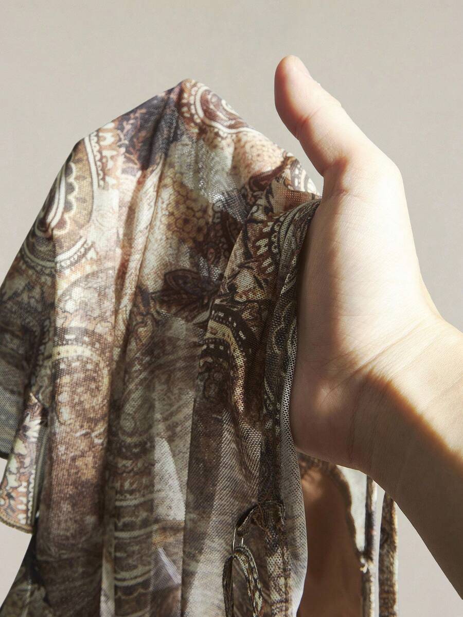Women's graphic print camisole top featuring thin spaghetti straps, a backless cut, and an asymmetrical hem.