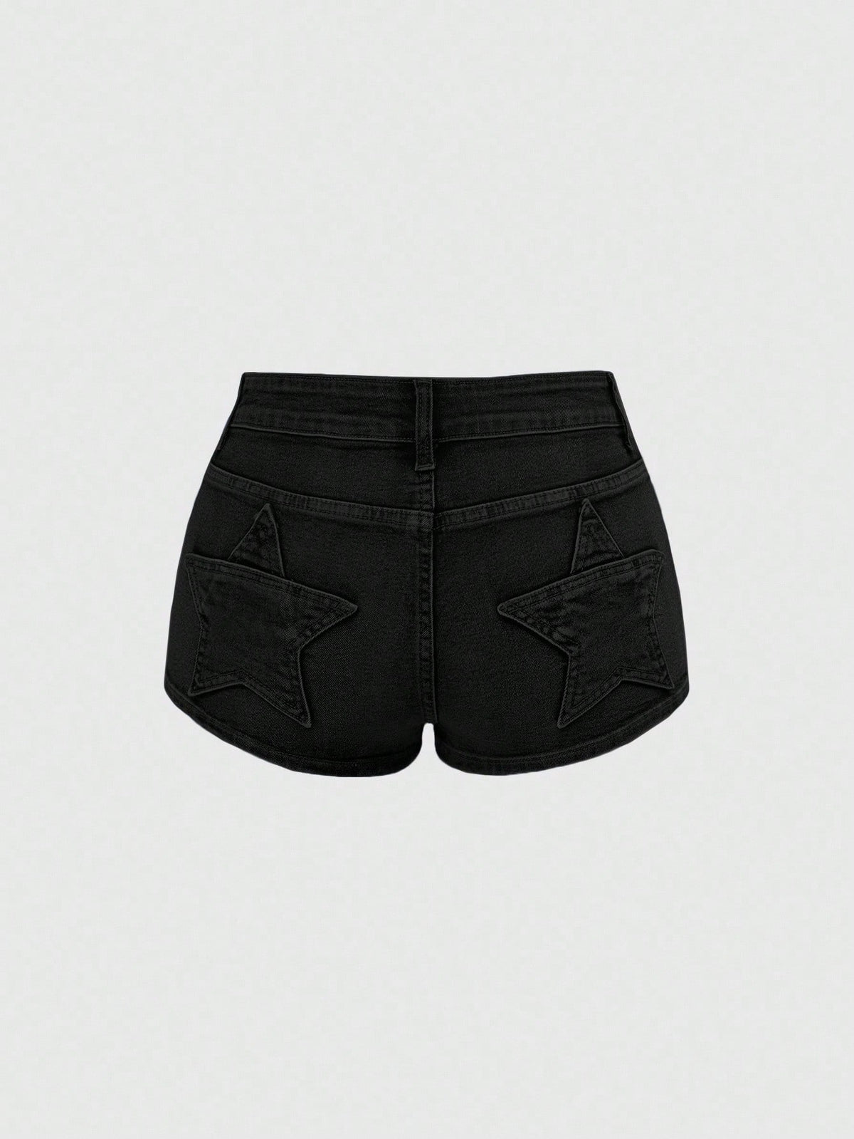 Women's ultra low waist mini shorts with back pockets, zipper fly, button detail, random print, and star patch in a grunge punk Y2K style.