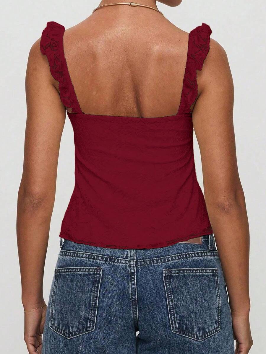 Sleeveless cami tank top featuring contrast lace patchwork design, ruffle spaghetti straps, and bow decor.