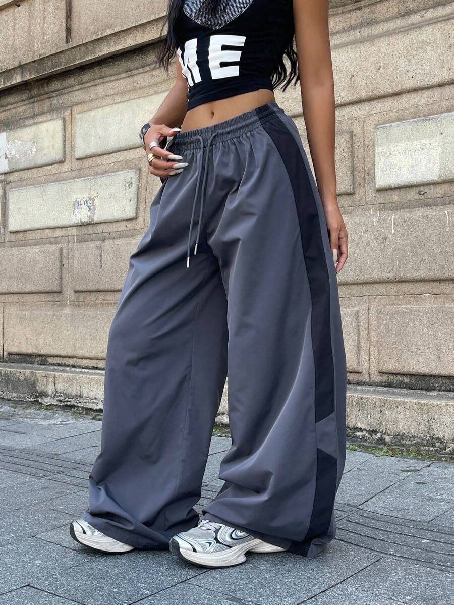 Women's plus size loose straight leg pants featuring a black and white color block design with side stripes and an elastic drawstring waist.