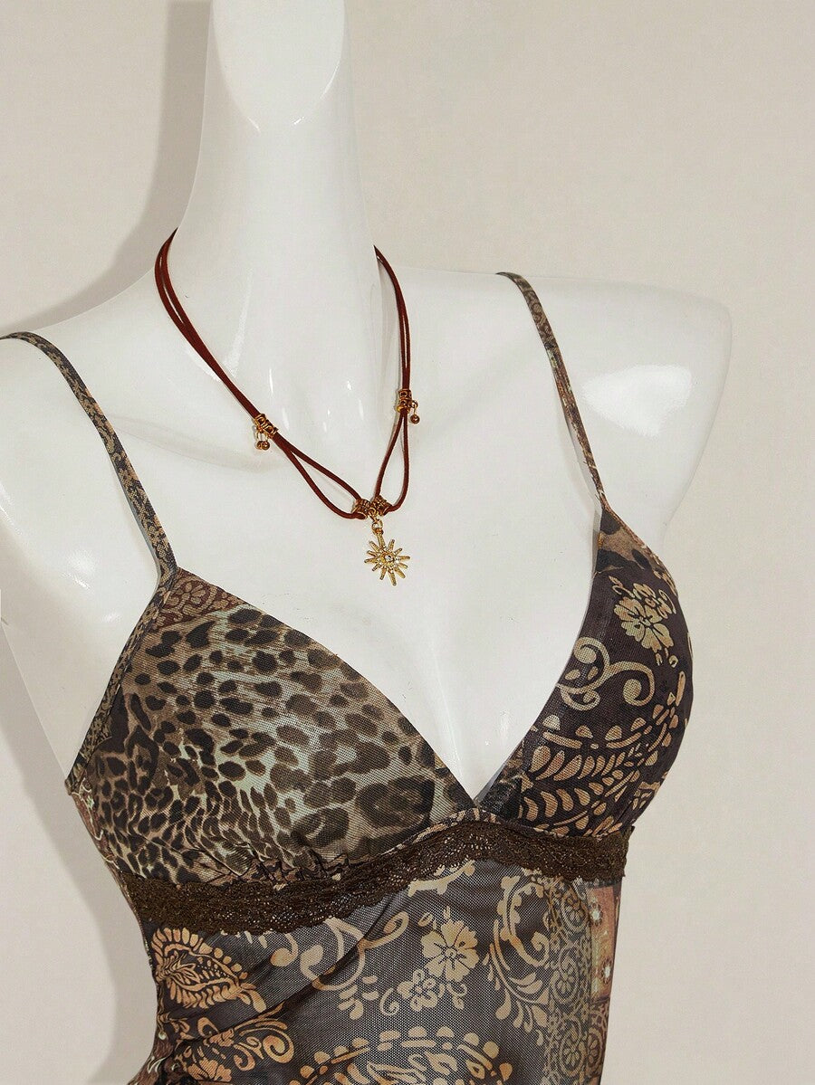 Women's graphic print camisole top featuring thin spaghetti straps, a backless cut, and an asymmetrical hem.