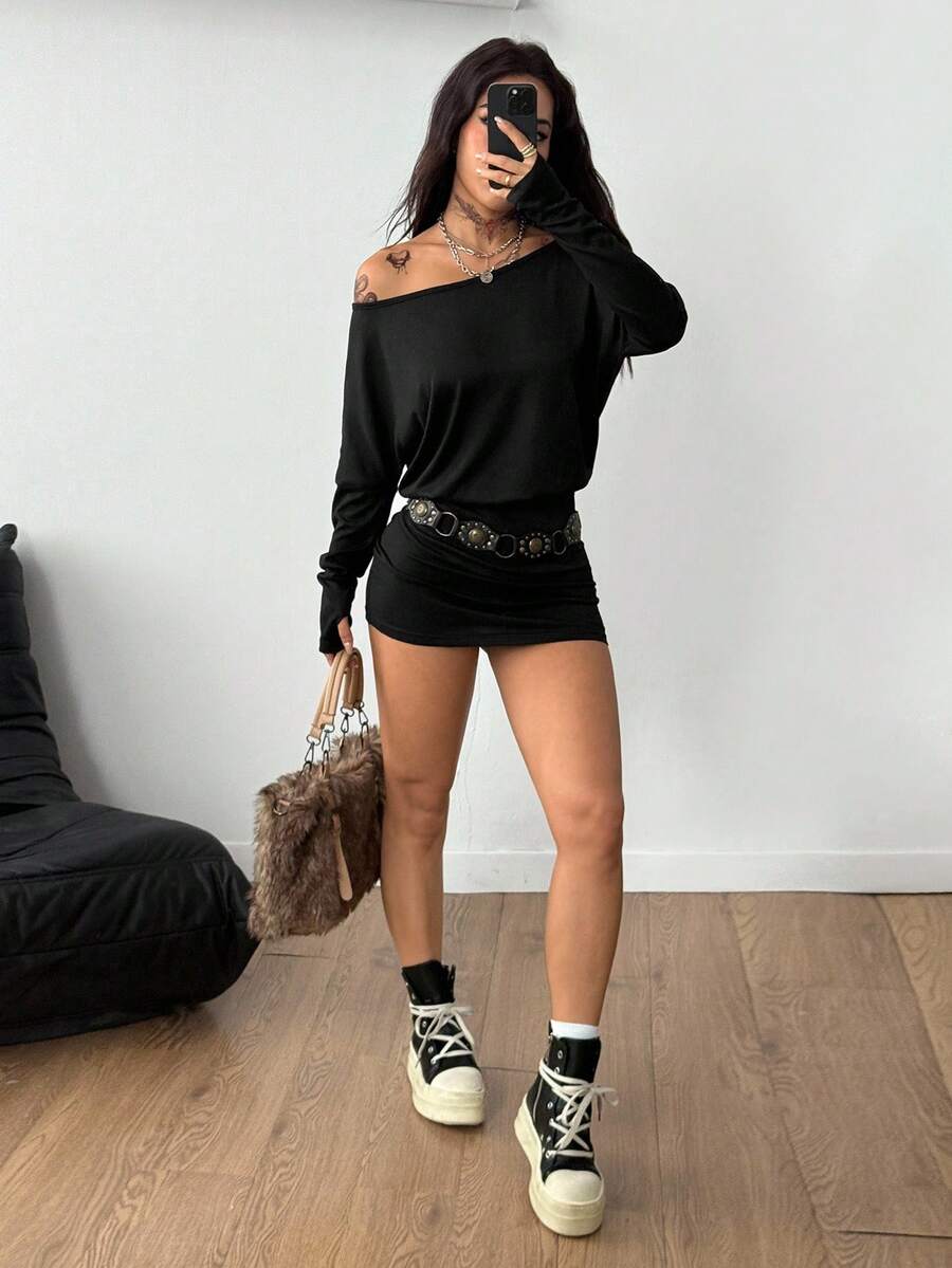 Women's long sleeve bodycon mini dress in black knitted fabric with an asymmetrical neckline and ruched accents.