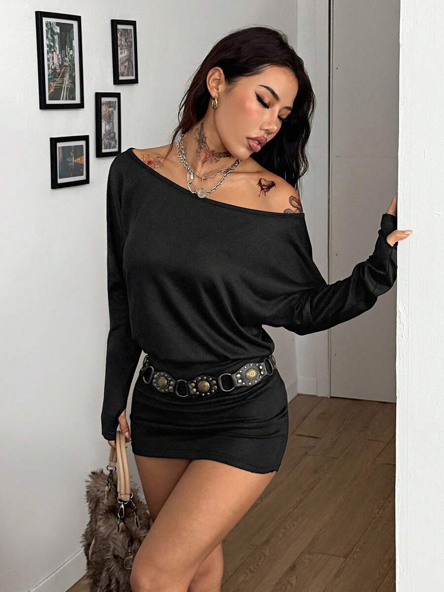 Women's long sleeve bodycon mini dress in black knitted fabric with an asymmetrical neckline and ruched accents.