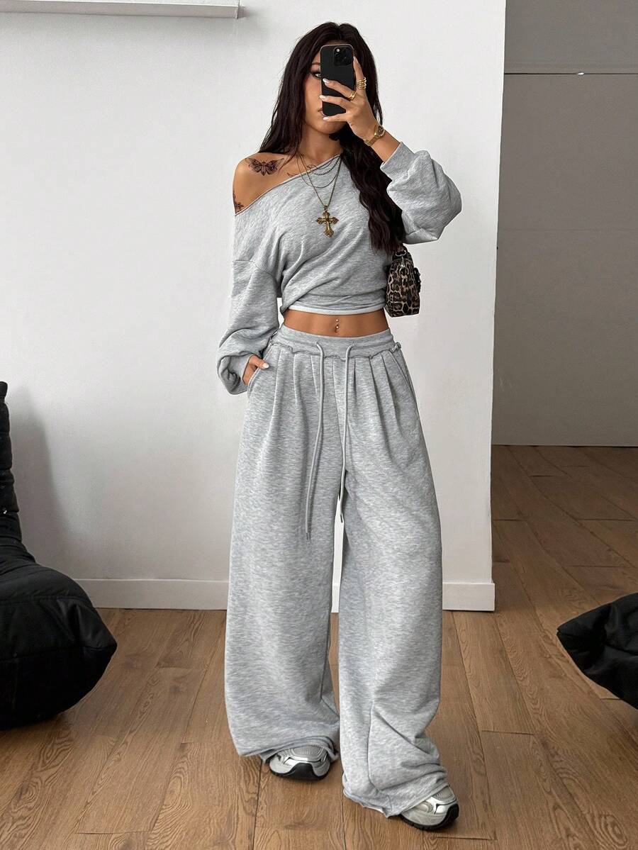 Women's two-piece casual lounge set featuring a loose drop-shoulder long sleeve sweatshirt and high-waist drawstring sweatpants with pockets.