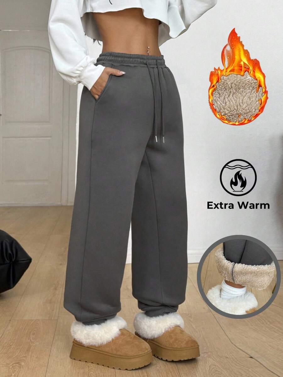 Women's casual grey jogger pants featuring a loose fit, mid-rise cut, and adjustable drawstring waistband.