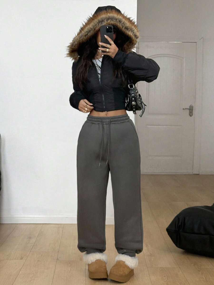 Women's casual grey jogger pants featuring a loose fit, mid-rise cut, and adjustable drawstring waistband.