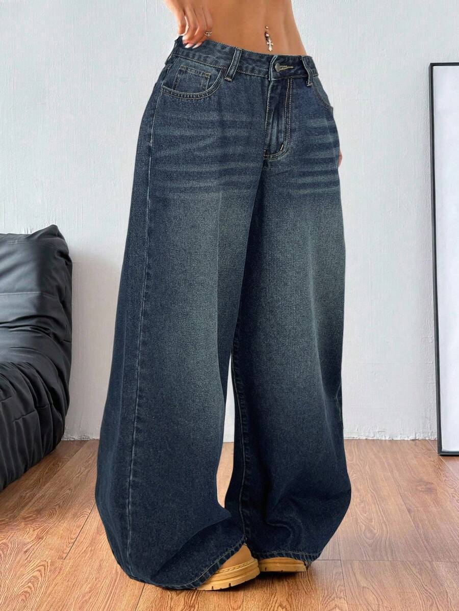 Plus size woman wearing high-waisted blue wide-leg denim jeans with classic pockets and zipper fly.