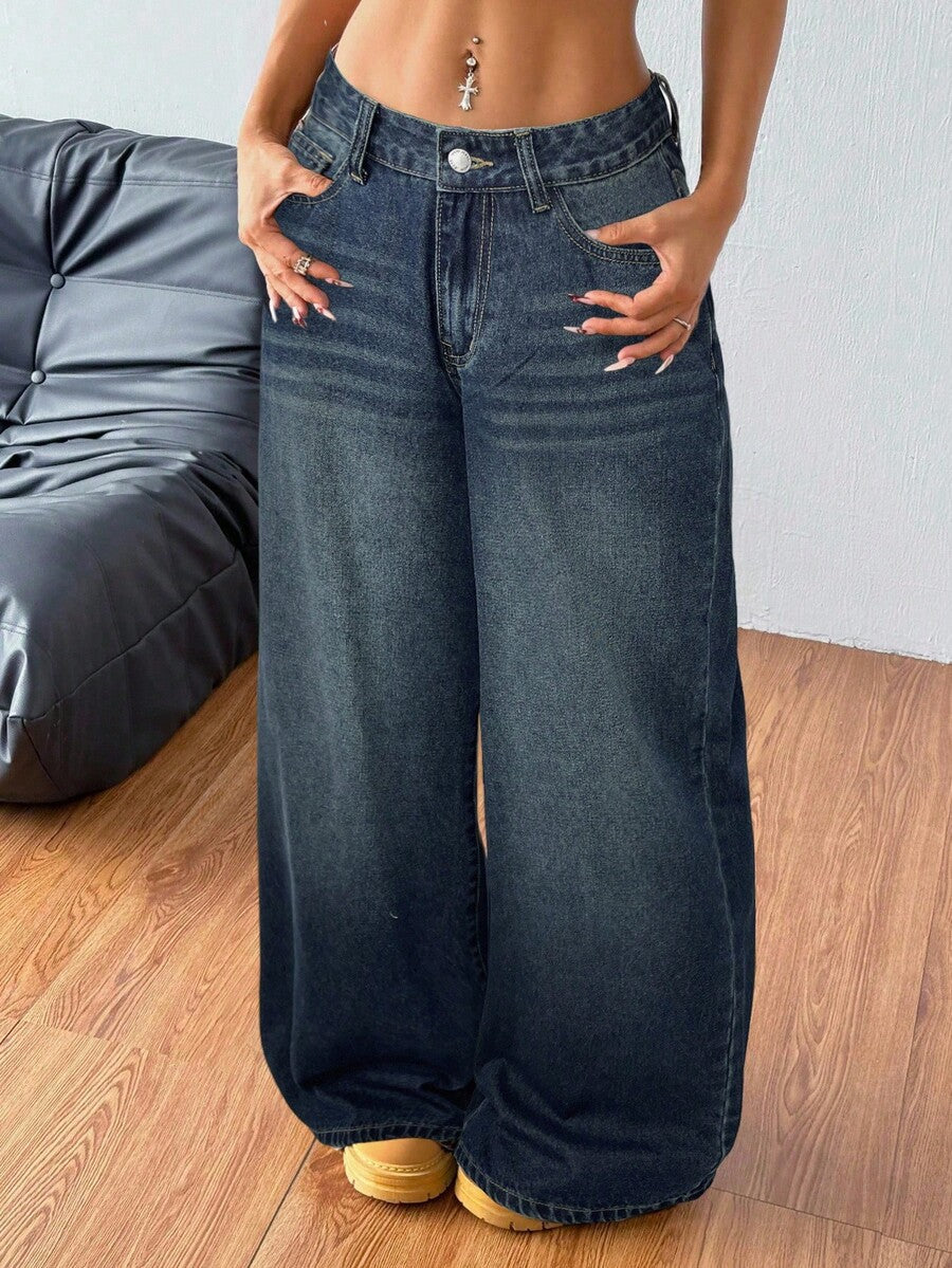 Plus size woman wearing high-waisted blue wide-leg denim jeans with classic pockets and zipper fly.