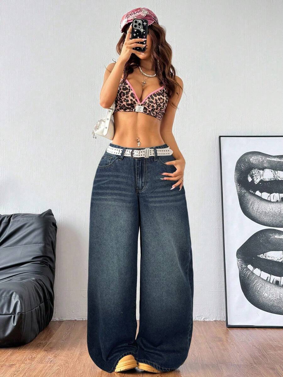 Plus size woman wearing high-waisted blue wide-leg denim jeans with classic pockets and zipper fly.