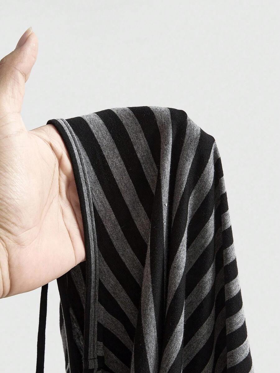 Women's striped t-shirt featuring an asymmetric cold shoulder neckline, batwing short sleeves, and ruched drawstring details in a loose knit fit.