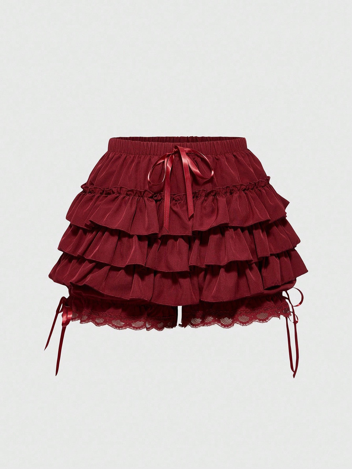 Women's tiered ruffle skort shorts featuring an elastic mid waist with front tie knot detail in woven fabric.