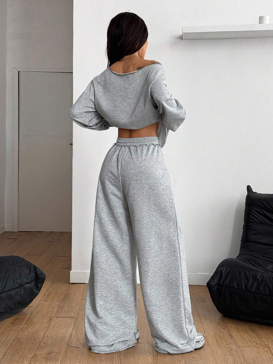 Women's two-piece casual lounge set featuring a loose drop-shoulder long sleeve sweatshirt and high-waist drawstring sweatpants with pockets.
