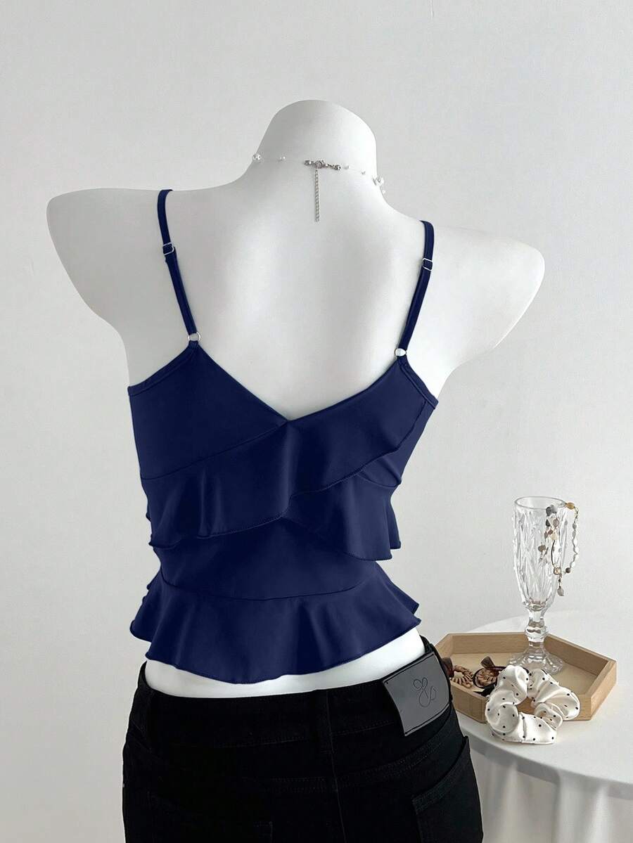 Women's solid color camisole top with thin spaghetti straps, tiered layers, and a flared ruffled hem.