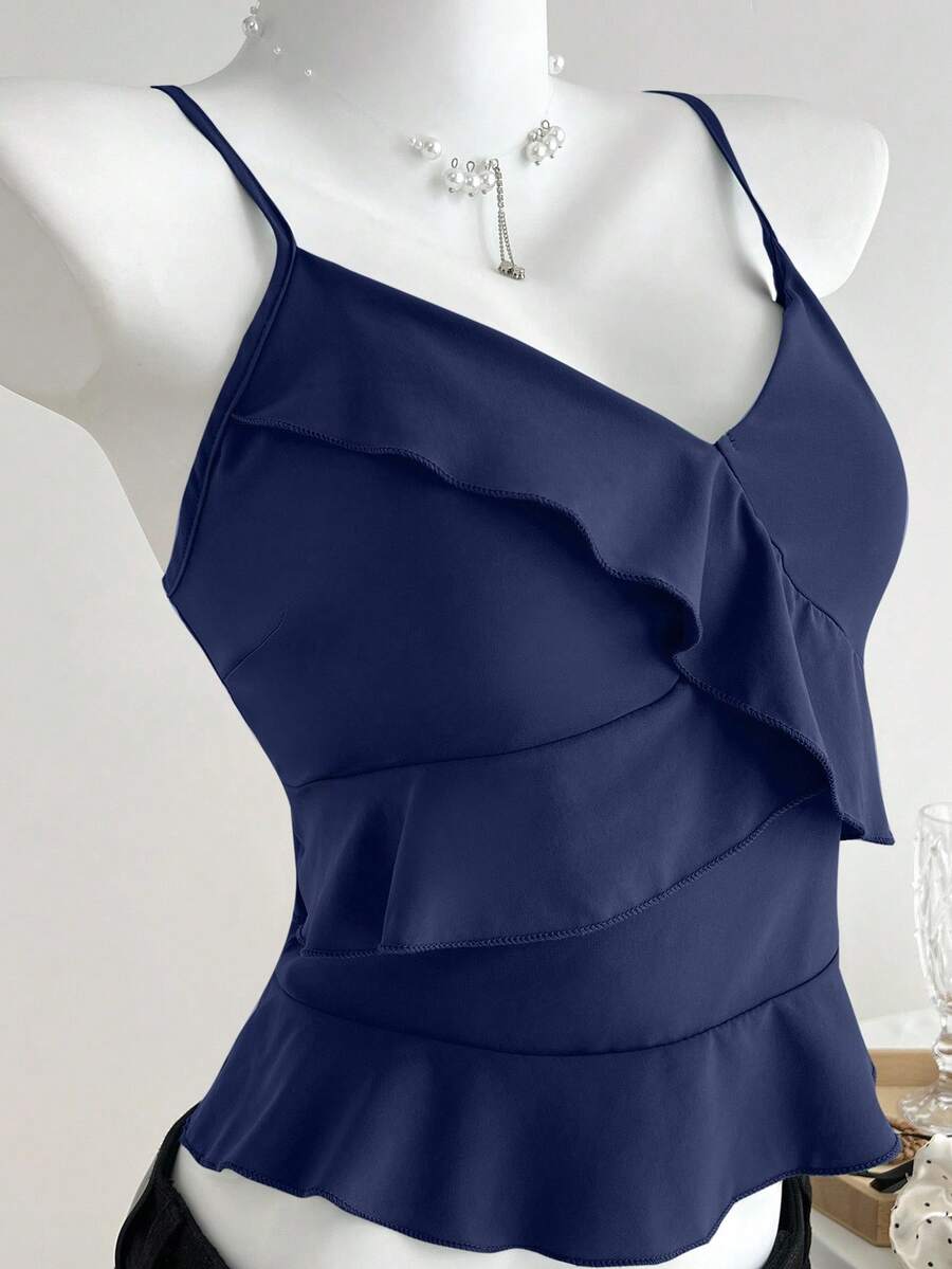 Women's solid color camisole top with thin spaghetti straps, tiered layers, and a flared ruffled hem.