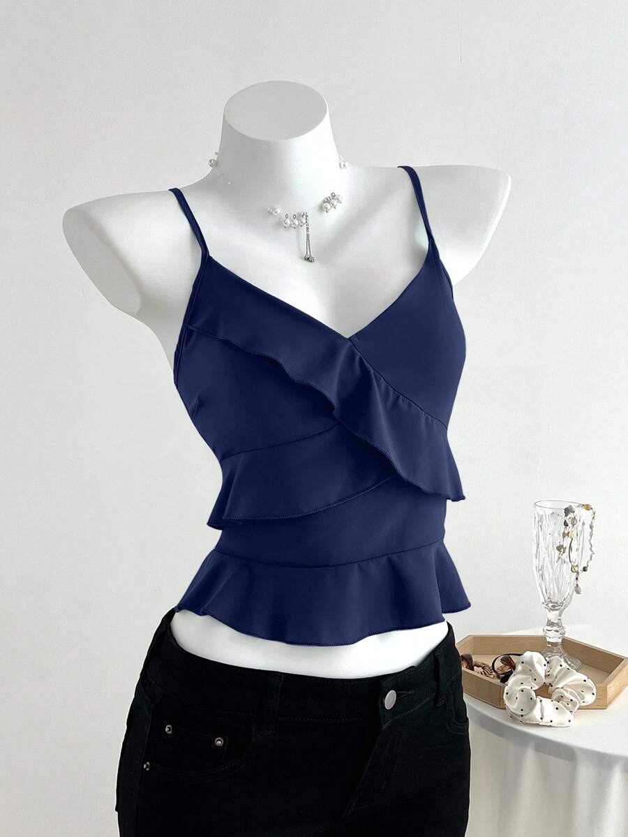 Women's solid color camisole top with thin spaghetti straps, tiered layers, and a flared ruffled hem.