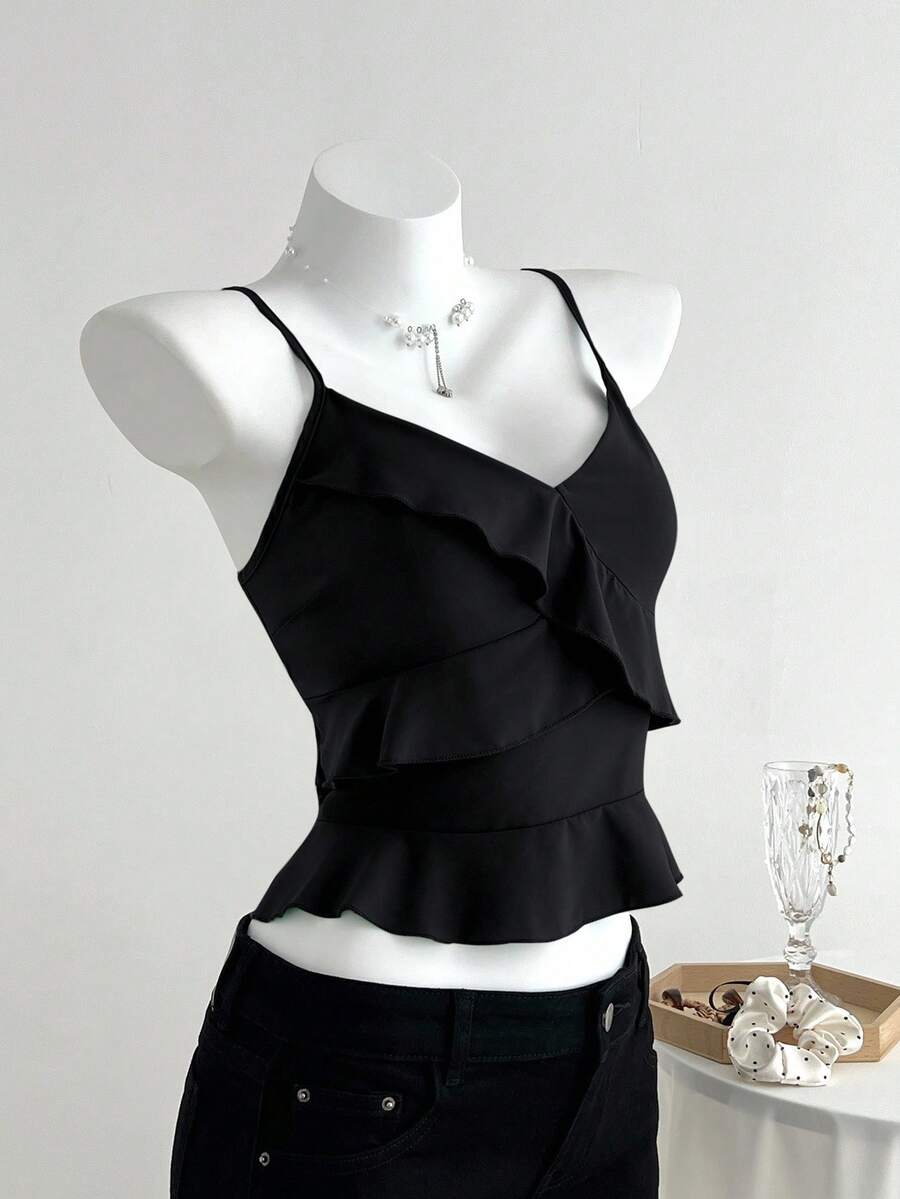Women's solid color camisole top with thin spaghetti straps, tiered layers, and a flared ruffled hem.